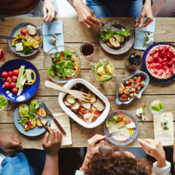 A birds eye view of people eating at a table with colourful food.