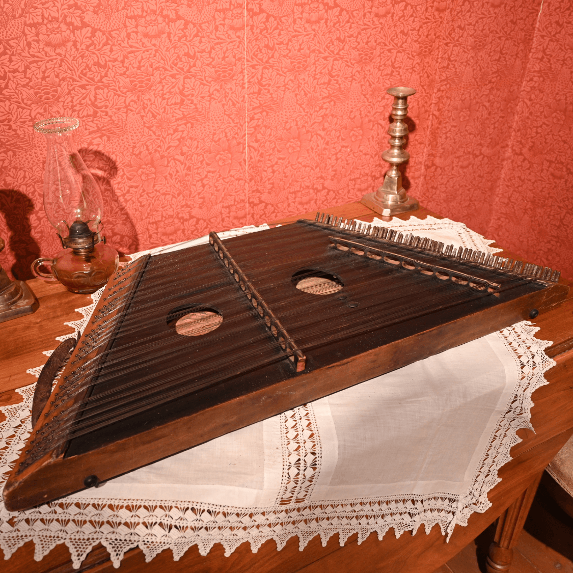 A stringed instrument displayed on a table with a white table cloth.