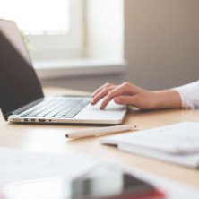 Person using a laptop and notebook